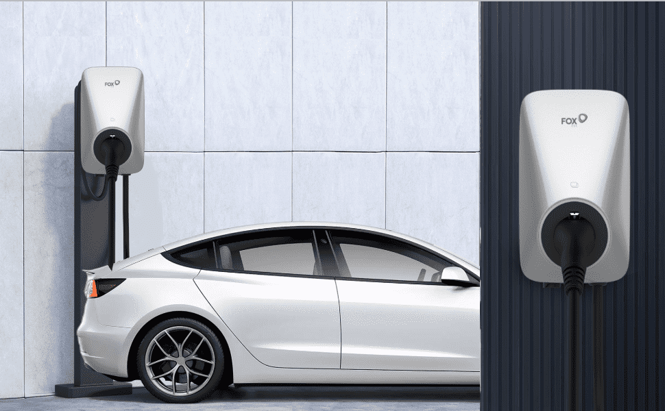 Im Freien lädt eine silberne FoxESS 11kW Wallbox ein Auto auf. Die Wallbox bietet eine einfache Installation mit Wand- oder Pfostenmontage und einem 6 Meter langen Ladekabel für flexible Platzierung. Sie verfügt über Statusanzeigen und einen Not-Aus-Schalter, um den Ladevorgang schnell zu unterbrechen. FoxESS ist 2023 in das KfW 442 Förderprogramm aufgenommen, Kunden in Deutschland und Österreich profitieren von dieser Förderung.