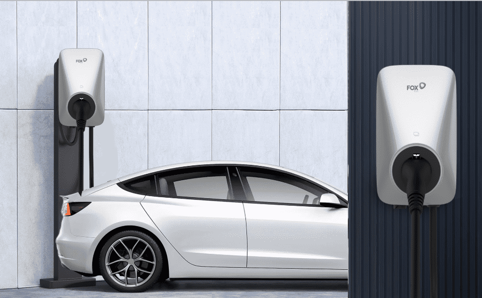 Im Freien lädt eine silberne FoxESS 7.3kW Wallbox ein Elektroauto. Die Wallbox lässt sich einfach an Wand oder Pfosten montieren und kommt mit einem 6 Meter langen Ladekabel für flexible Platzierung. Sie bietet Statusanzeigen und einen Not-Aus-Schalter für schnelle Sicherheit. FoxESS ist 2023 im KfW 442 Förderprogramm gelistet, Kunden in Deutschland und Österreich profitieren von dieser Förderung.